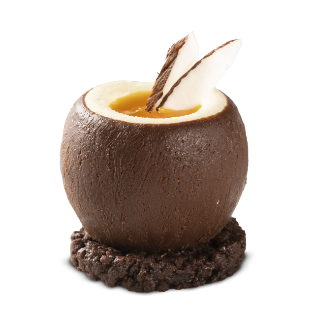 Coajă rotundă de ciocolată umplută cu cremă de portocale, decorată cu fulgi de ciocolată albă și neagră, pe biscuit