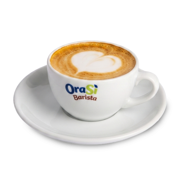 Ceașcă albă de cappuccino cu latte art în formă de inimă, etichetă "OraSì Barista", pe farfurioară asortată, fundal alb