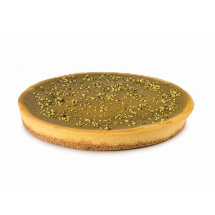 Tartă rotundă cu glazură fină de caramel, blat crocant și fistic măcinat presărat deasupra.
