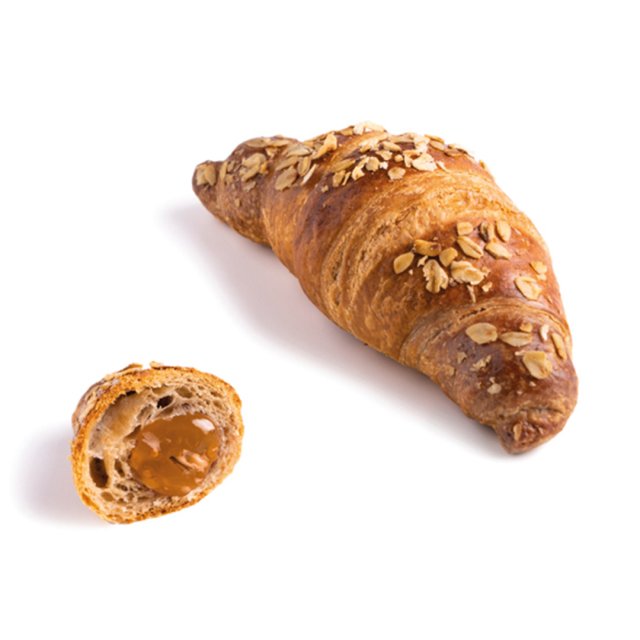Croissant auriu cu ovăz, o bucată mai mică tăiată dezvăluie umplutura de caramel, pe fundal alb