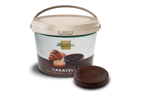 Găleată albă cu cremă tartinabilă Master Martini Caravella lângă un disc de ciocolată fondente cu model în relief