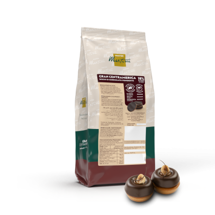 Pungă de disc-uri de ciocolată neagră Master Martini Gran Centramerica (18% cacao) lângă două deserturi glazurate.